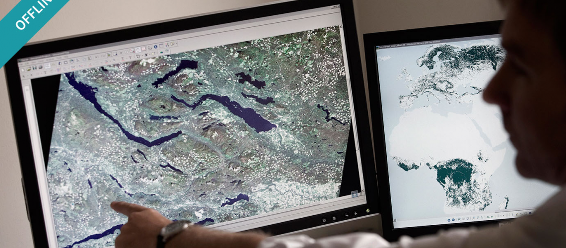 Man pointing to aerial mapping on a screen