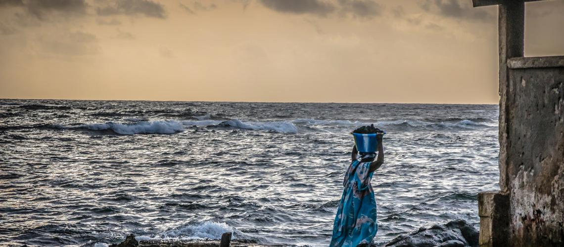 Woman carry resource in front of the sea