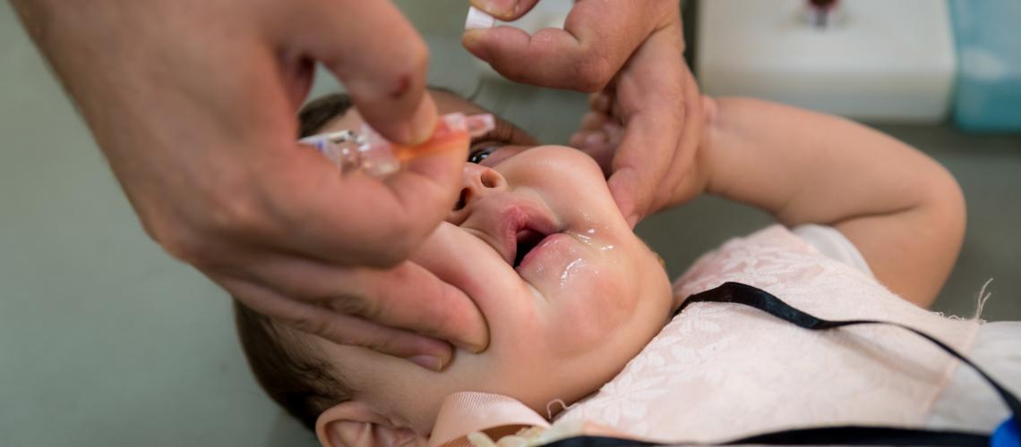 Baby getting administered liquids orally