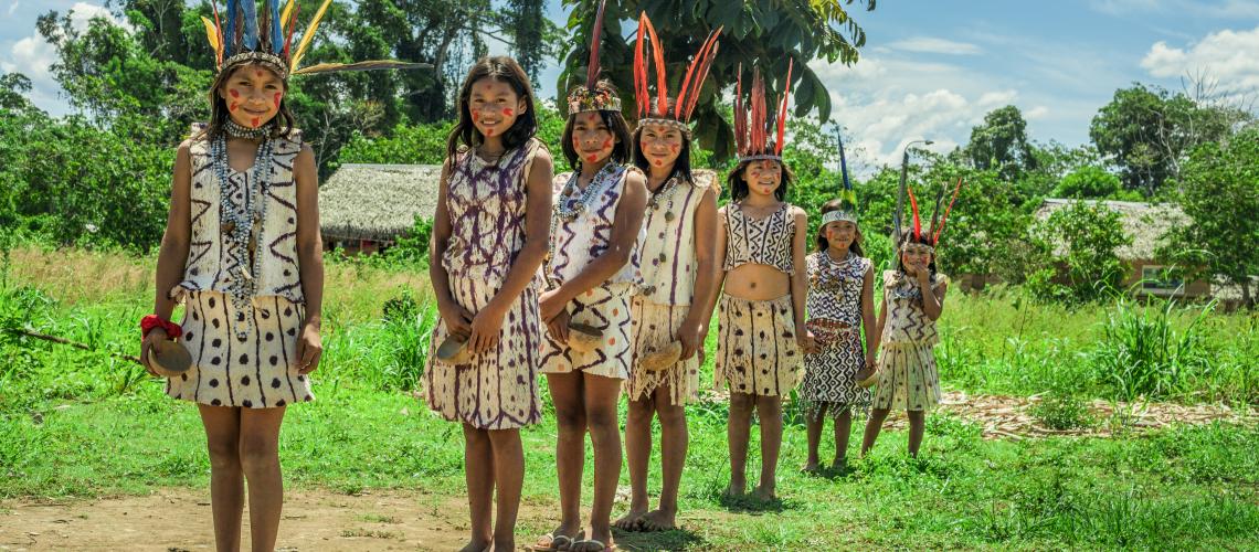 A group of female children standing outside dressed in indigenous garments
