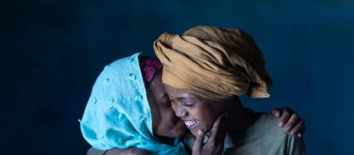 Two women hugging and whispering