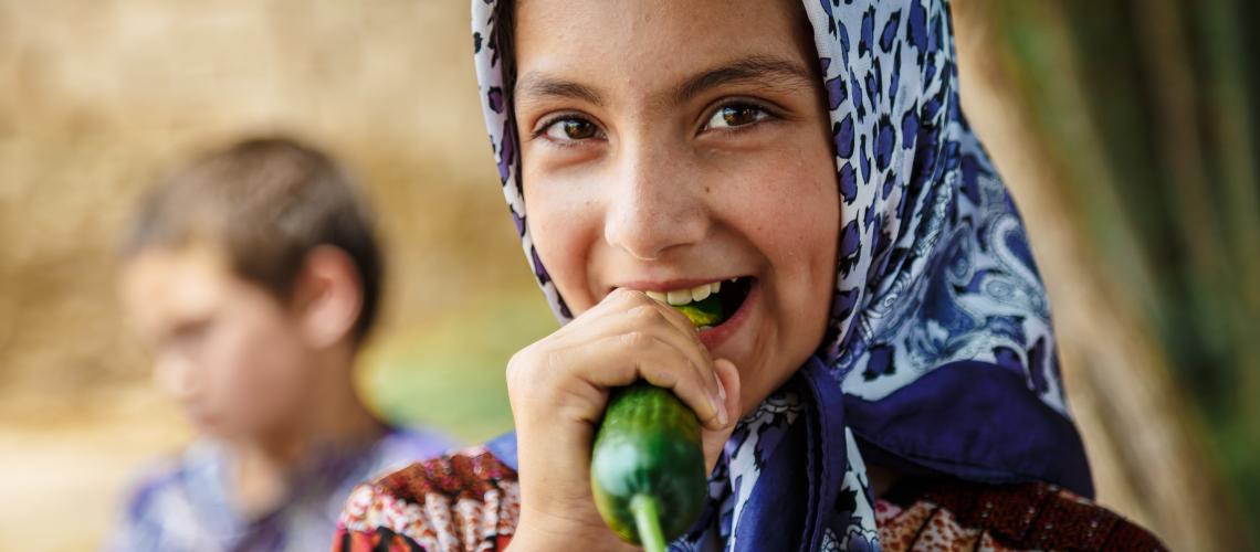 Girl eating a cucumber
