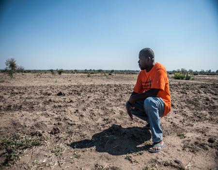 Man kneeling on dry land