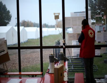 Humanitarian aid worker looking out to white tents