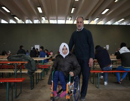 Woman in a wheelchair with man behind her