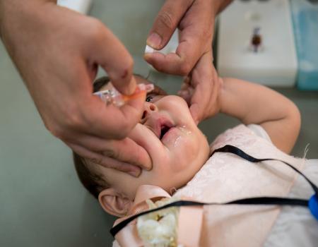 Baby getting administered liquids orally