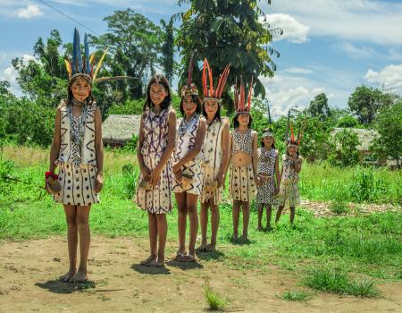 A group of female children standing outside dressed in indigenous garments