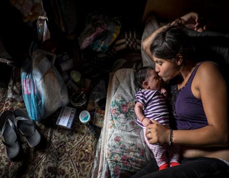 Woman laying on a mattress with a baby