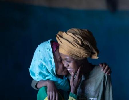 Two women hugging and whispering