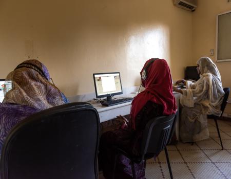 A group of women sitting in front of computers