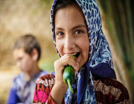 Girl eating a cucumber