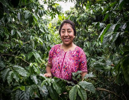 Woman surrounded by trees smiling at the camera